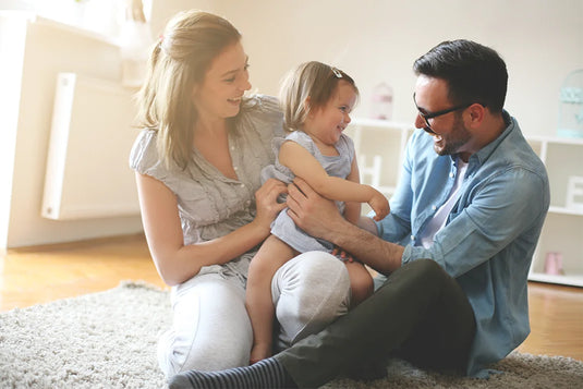 couple smiling holding young daughter